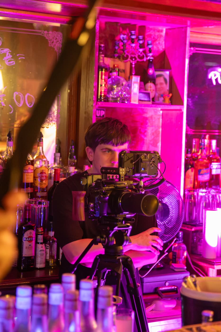 Kameramann an einem Set mit Neonlicht